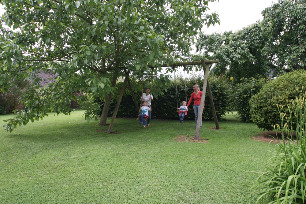 Tuin met zandbak en schommel